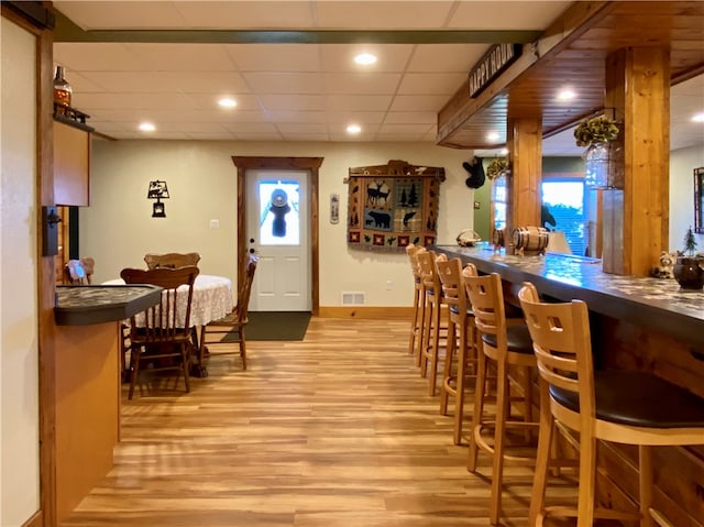 interior space with a drop ceiling and light wood-type flooring