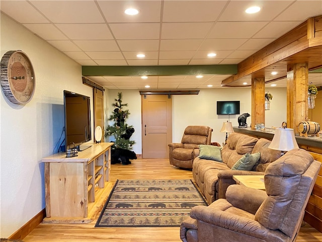 living room featuring light hardwood / wood-style floors and a drop ceiling