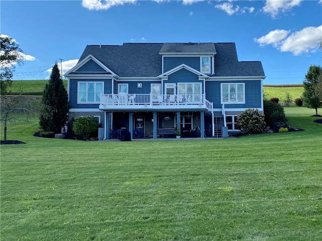 back of property with a wooden deck and a lawn