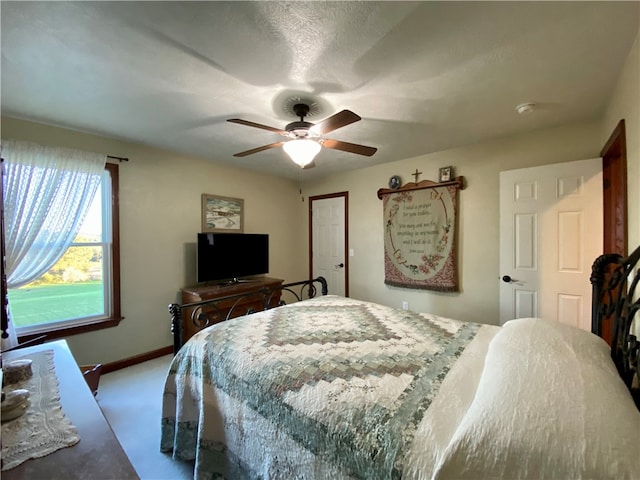 carpeted bedroom with a textured ceiling and ceiling fan