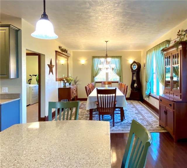 dining area featuring dark hardwood / wood-style floors, a chandelier, a textured ceiling, and separate washer and dryer