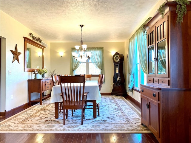 dining room featuring a wealth of natural light, a textured ceiling, a notable chandelier, and dark hardwood / wood-style floors