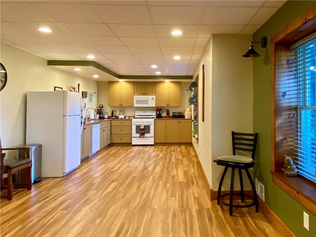 kitchen featuring light brown cabinets, light hardwood / wood-style flooring, a paneled ceiling, and white appliances