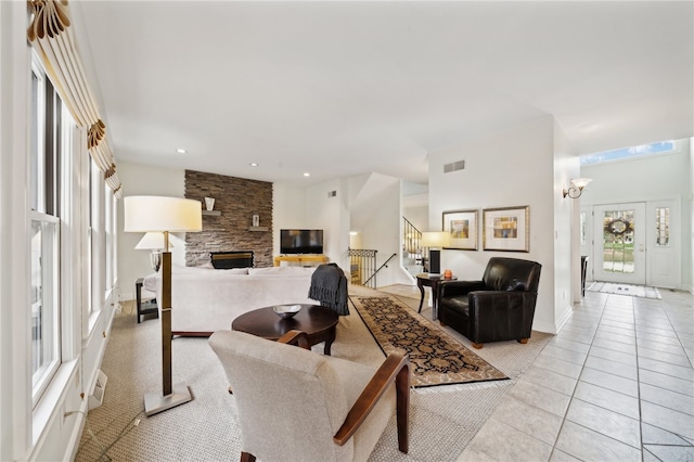 tiled living room featuring a stone fireplace