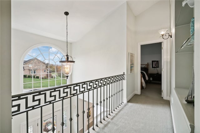 hallway featuring carpet flooring and vaulted ceiling