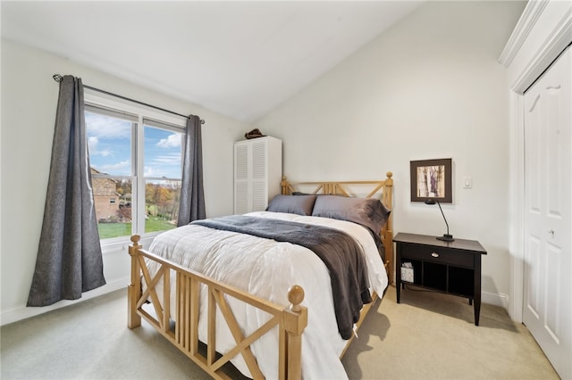 carpeted bedroom with a closet and vaulted ceiling