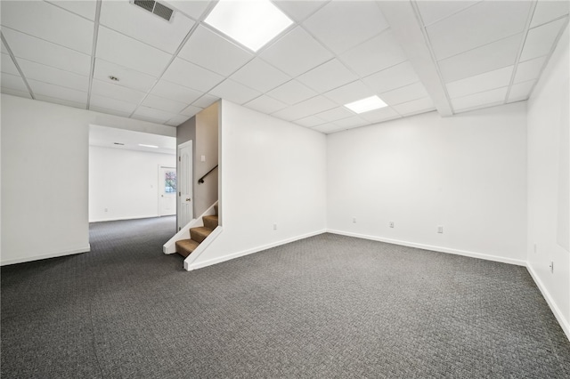 empty room featuring a drop ceiling and dark carpet