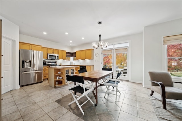 tiled dining room featuring a wealth of natural light and a chandelier