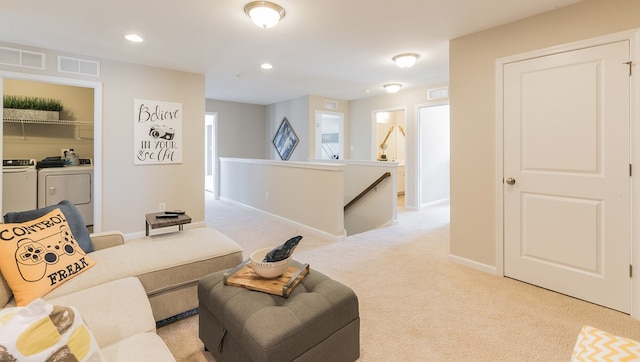 living room with visible vents, baseboards, light colored carpet, separate washer and dryer, and recessed lighting