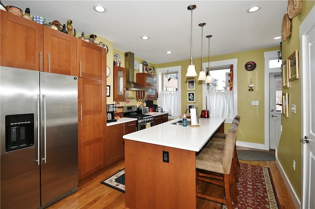 kitchen featuring a kitchen island, stainless steel appliances, sink, a breakfast bar, and light hardwood / wood-style floors