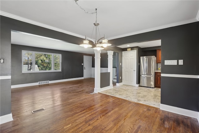 interior space with ornamental molding, a chandelier, ornate columns, and dark hardwood / wood-style floors