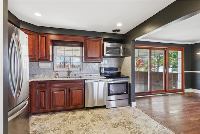 kitchen featuring sink, appliances with stainless steel finishes, light hardwood / wood-style flooring, and plenty of natural light