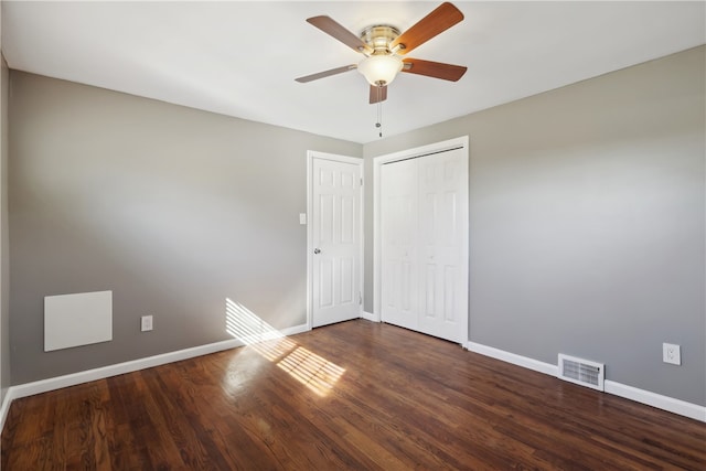 unfurnished bedroom with a closet, dark hardwood / wood-style floors, and ceiling fan