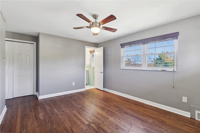 unfurnished bedroom with a closet, dark hardwood / wood-style floors, and ceiling fan