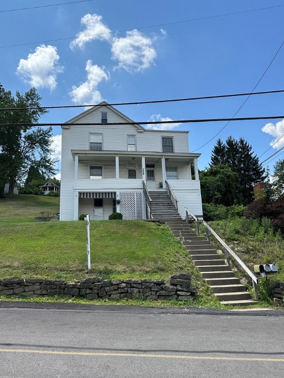 view of front of home with a front yard and covered porch