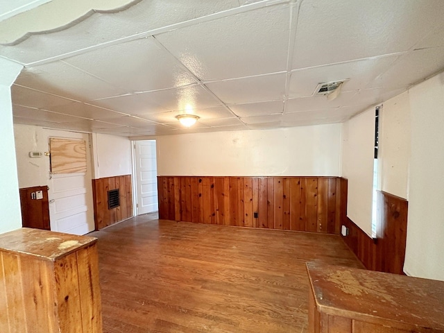 unfurnished room with wooden walls and wood-type flooring