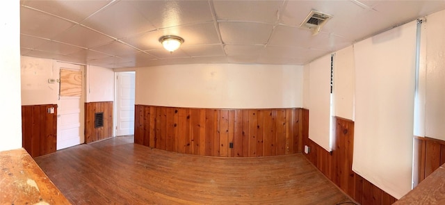 unfurnished room featuring dark hardwood / wood-style floors and wood walls