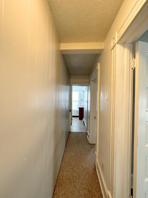 hallway with tile patterned floors and a textured ceiling