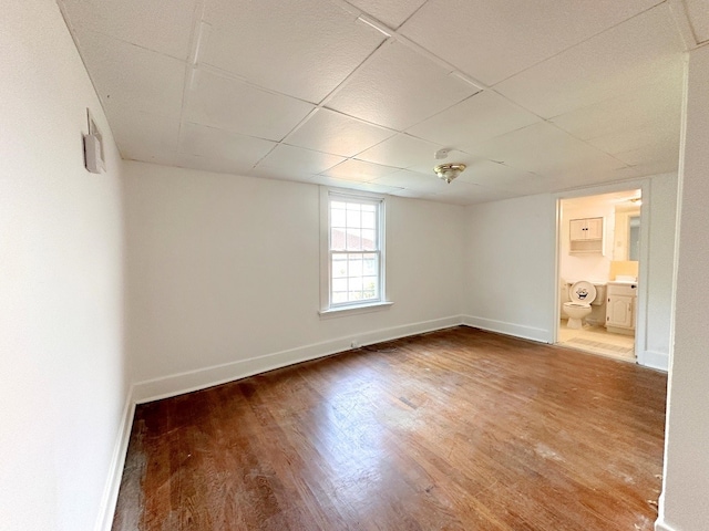 unfurnished room featuring hardwood / wood-style flooring and a paneled ceiling