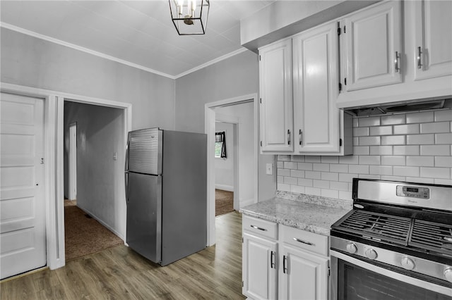 kitchen featuring ornamental molding, white cabinetry, stainless steel appliances, and light wood-type flooring