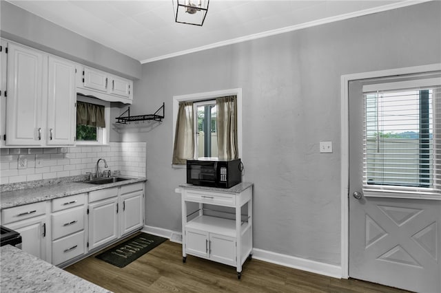 kitchen featuring decorative backsplash, white cabinets, dark hardwood / wood-style flooring, crown molding, and sink