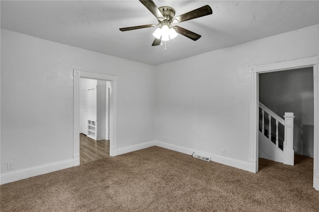 unfurnished room with dark carpet and ceiling fan