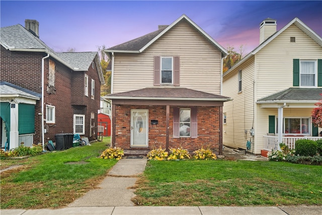 front facade featuring a yard and covered porch