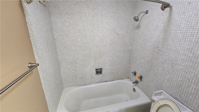 bathroom featuring tiled shower / bath and toilet