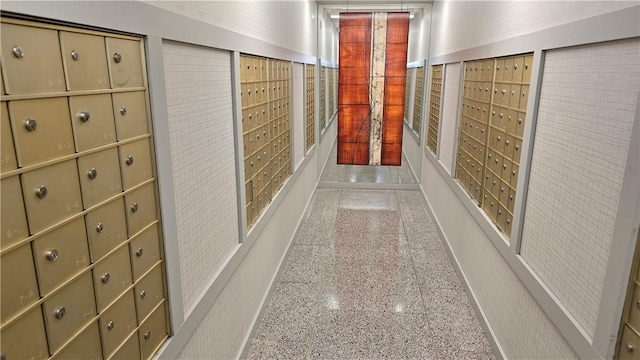 hallway featuring mail area and granite floors