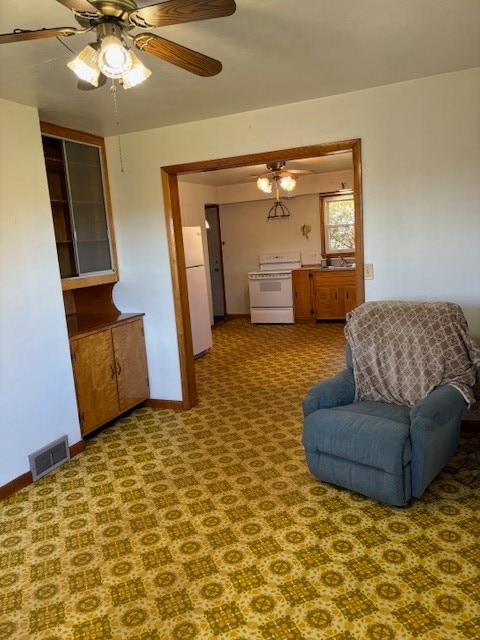 living area with sink, carpet flooring, and ceiling fan