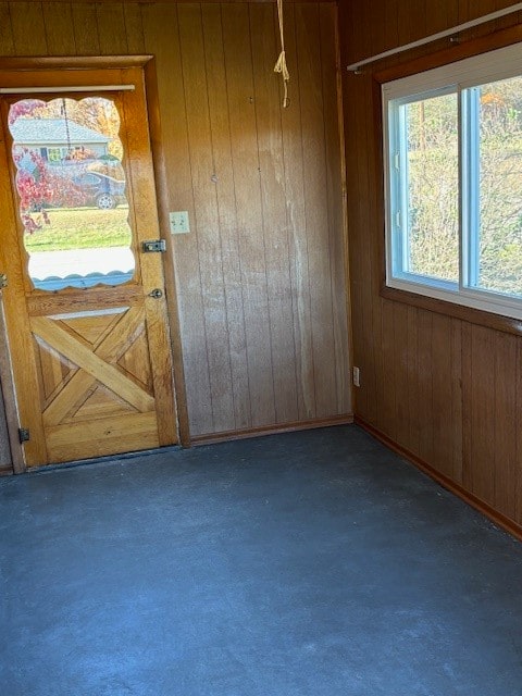 doorway to outside with wood walls