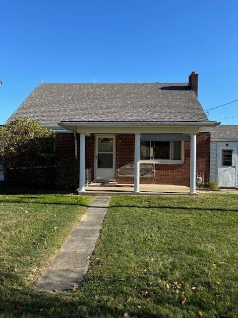 view of front of house with covered porch and a front lawn