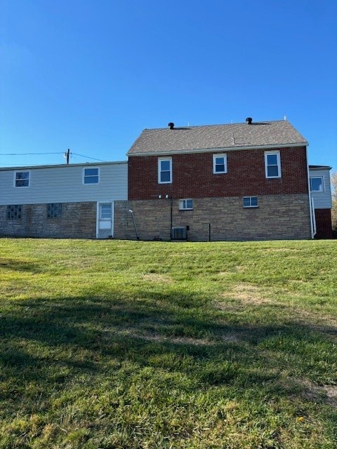 back of property featuring a yard and central air condition unit