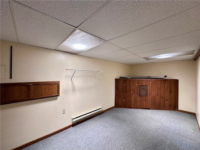 basement with carpet flooring, a drop ceiling, and baseboard heating