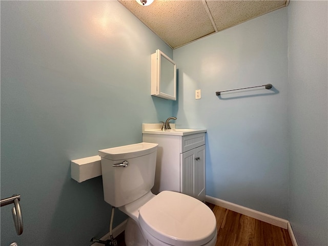 bathroom with toilet, hardwood / wood-style flooring, and vanity