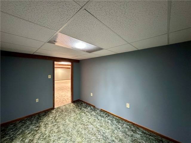 basement with a paneled ceiling and carpet floors