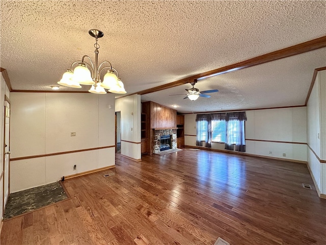 unfurnished living room with a fireplace, a textured ceiling, ceiling fan with notable chandelier, and dark hardwood / wood-style flooring