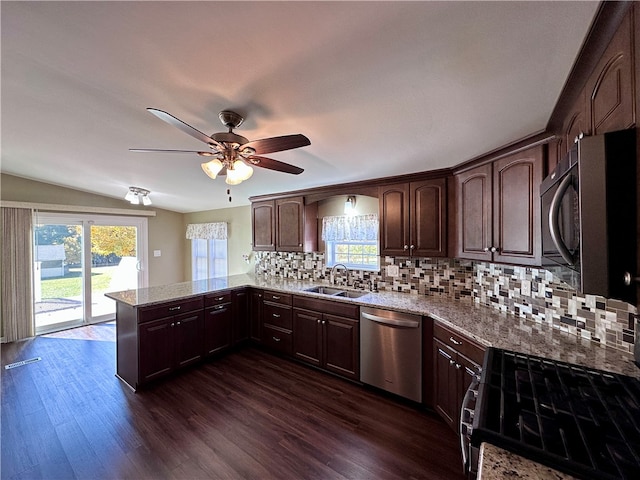 kitchen featuring kitchen peninsula, appliances with stainless steel finishes, dark hardwood / wood-style flooring, and plenty of natural light