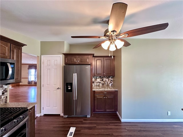 kitchen with decorative backsplash, dark brown cabinets, stainless steel appliances, and dark hardwood / wood-style flooring