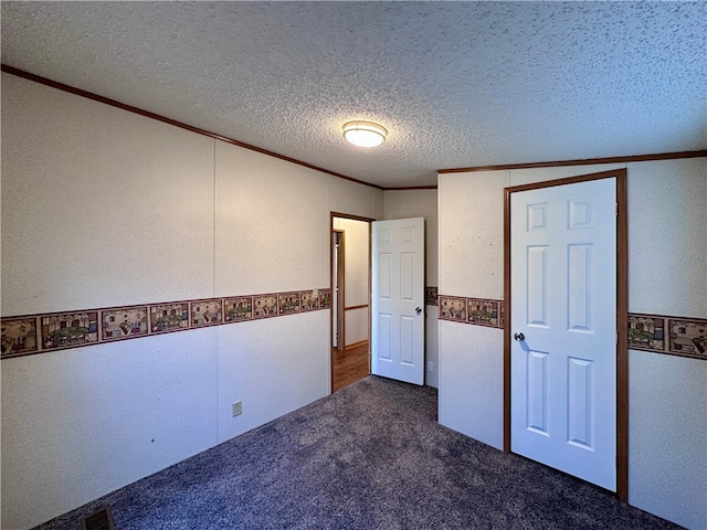 unfurnished bedroom featuring crown molding, a textured ceiling, vaulted ceiling, and dark colored carpet