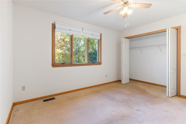 unfurnished bedroom with light carpet, a closet, and ceiling fan