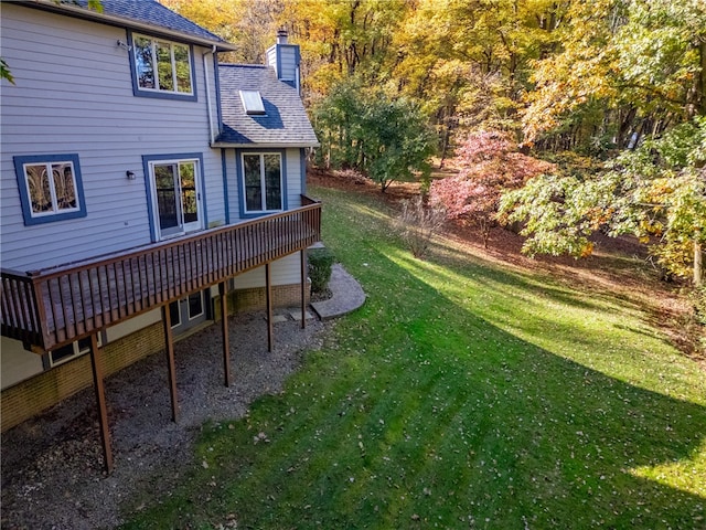 rear view of property featuring a yard and a deck