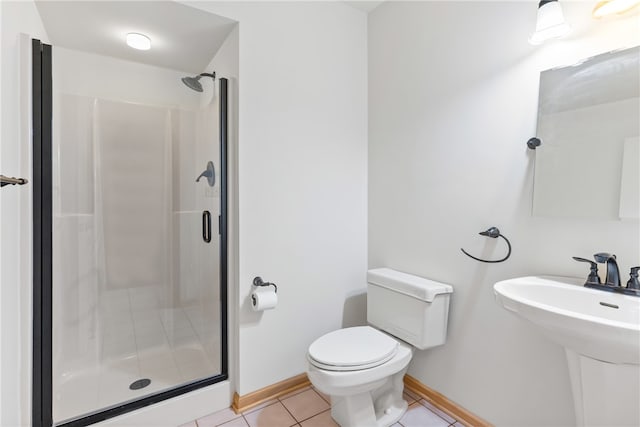 bathroom with tile patterned floors, sink, toilet, and an enclosed shower