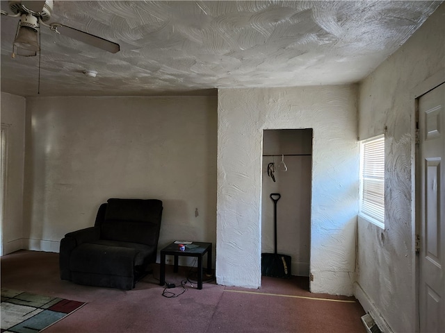 living area featuring ceiling fan and carpet flooring