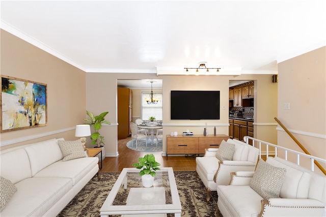 living room featuring dark hardwood / wood-style flooring, a notable chandelier, and crown molding