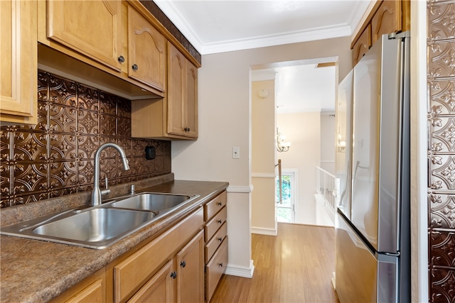 kitchen with crown molding, stainless steel refrigerator, decorative backsplash, sink, and light hardwood / wood-style flooring