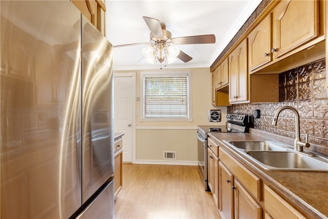 kitchen with stainless steel appliances, light hardwood / wood-style floors, sink, crown molding, and backsplash