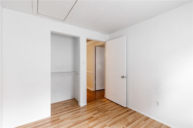 unfurnished bedroom with light hardwood / wood-style floors and a closet