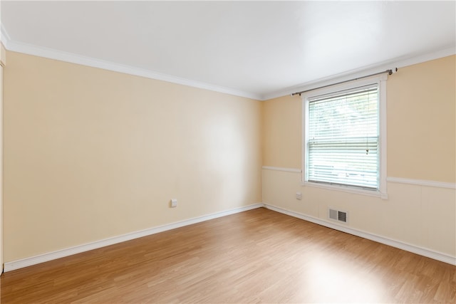 unfurnished room featuring light wood-type flooring and crown molding