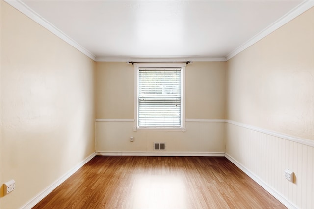 unfurnished room featuring hardwood / wood-style floors and ornamental molding